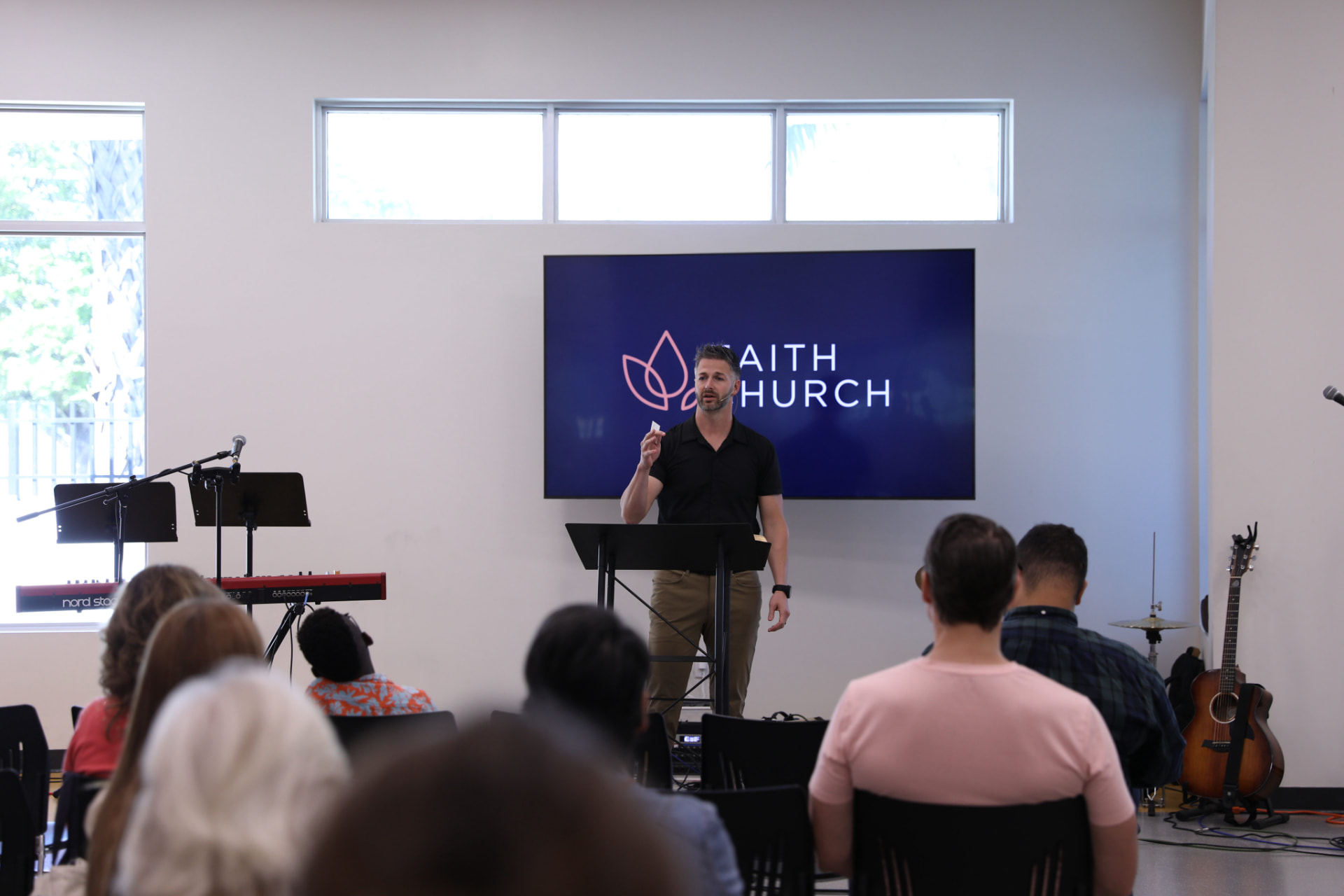 Pastor preaching from the Bible on a Sunday morning at Faith Church Miami